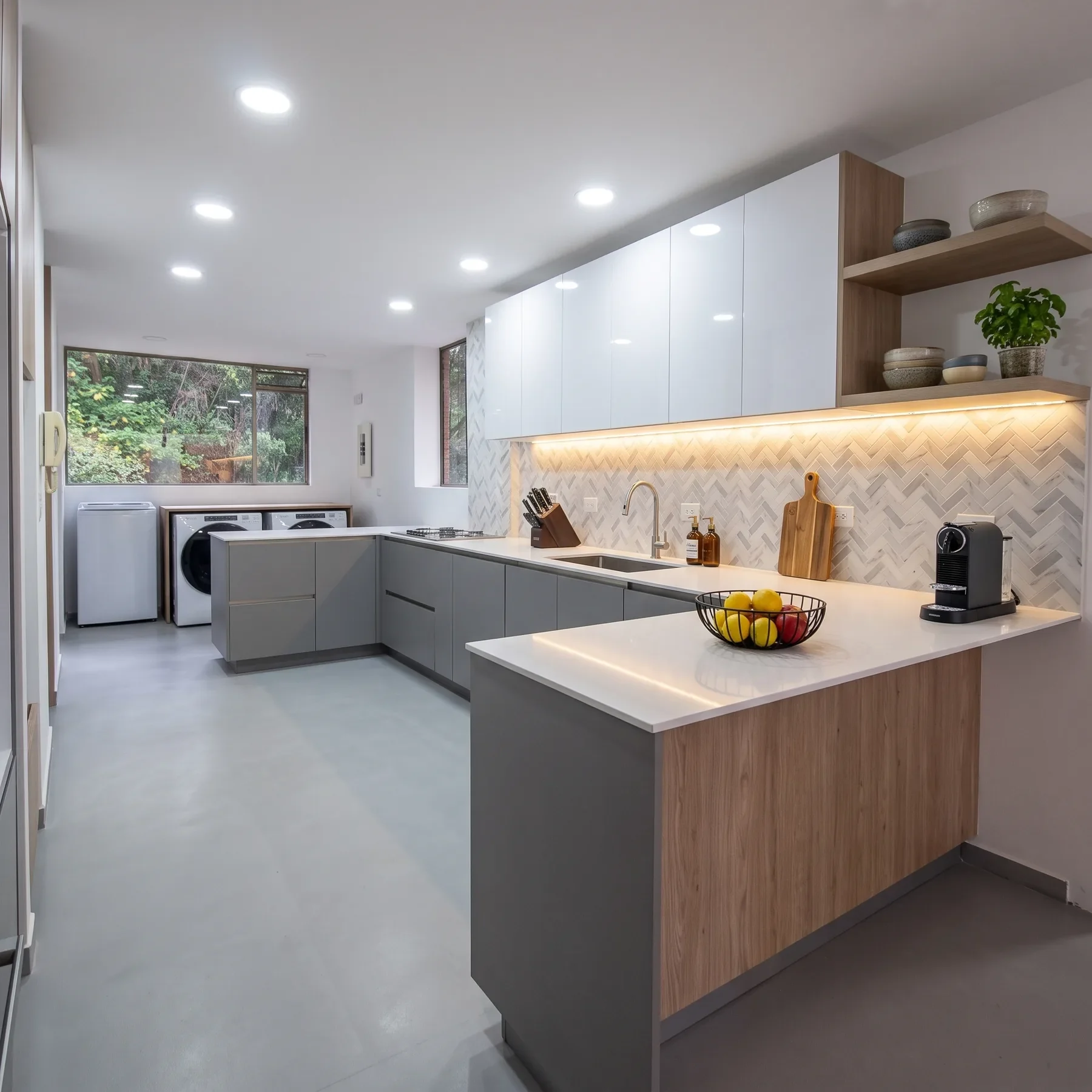 Cocina Bosques de la Cañada terminada: cocina en L con gabinetes grises y blancos, madera clara y luz LED