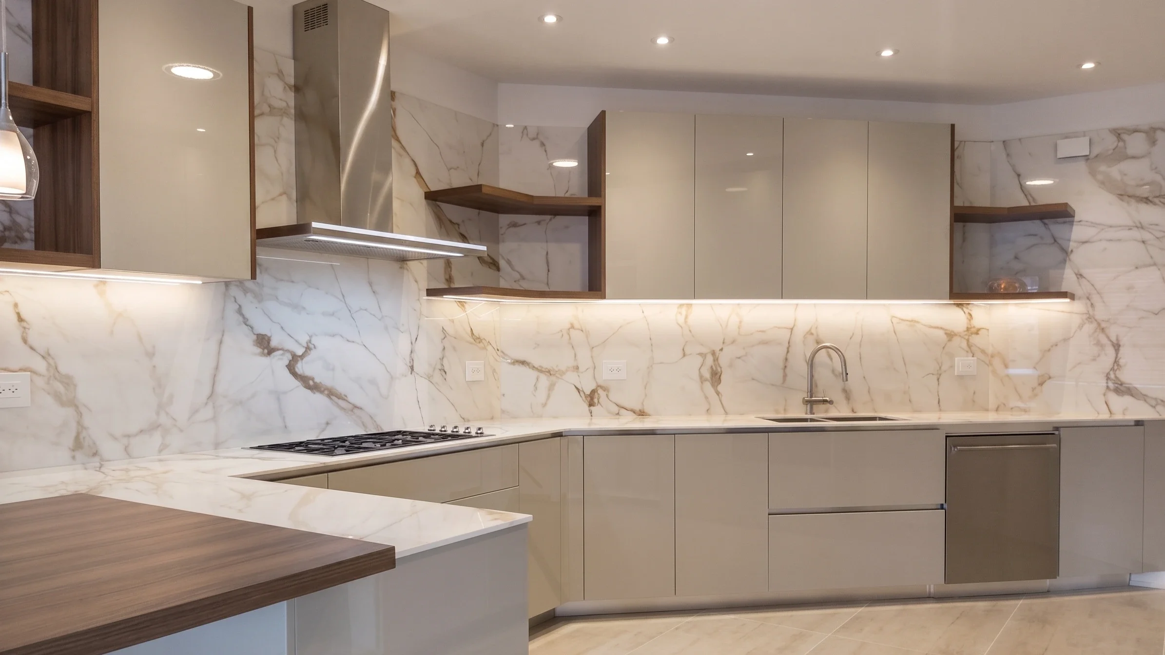 Cocina terminada con mármol, gabinetes champaña y luz LED bajo los muebles
