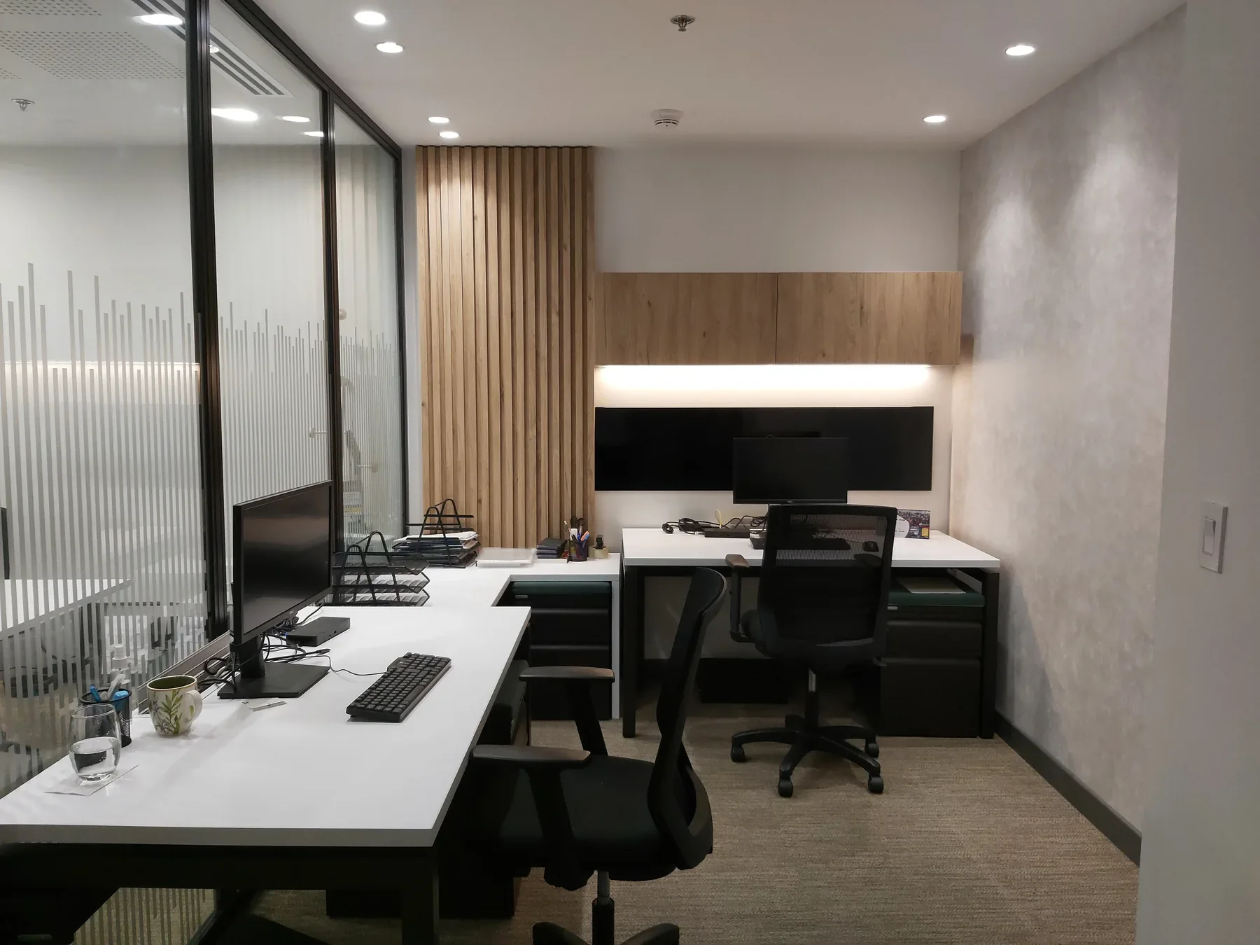 Oficinas Embajada: puestos de trabajo, panel de listones de madera y vidrio con película esmerilada